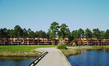 Herdade de Aroeira, vue 'une passerelle traversant un étang sur le golf Aroeira II avec les appartements en arrière plan